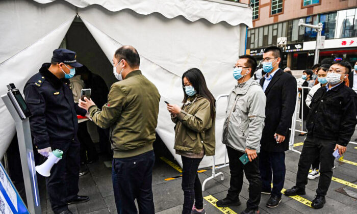 Des personnes font la queue pour recevoir une injection de rappel du vaccin contre le coronavirus COVID-19 dans une tente installée à l'extérieur d'un centre commercial à Pékin, le 1er novembre 2021. (Greg Baker/AFP via Getty Images)