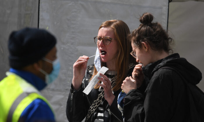 Deux femmes s’administrent un test Covid-19 dans un centre mobile de dépistage à Clapham Common, dans le sud de Londres, au Royaume-Uni, le 13 avril 2021. (Daniel Leal-Olivas/AFP via Getty Images)