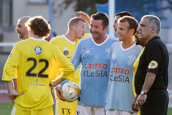 Karl Olive, maire de Poissy (au centre) et Emmanuel Macron (à sa droite) lors d'un évènement au stade de Poissy en octobre 2021. (LUDOVIC MARIN/AFP via Getty Images)