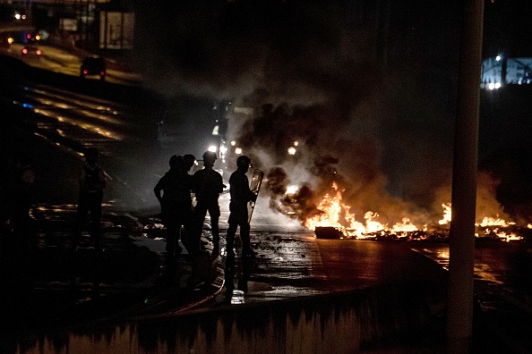 La police se tient près d'une barricade en feu sur une route à Le  Lamentin, en Martinique, le 30 novembre 2021. (Photo : ALAIN JOCARD/AFP via Getty Images)