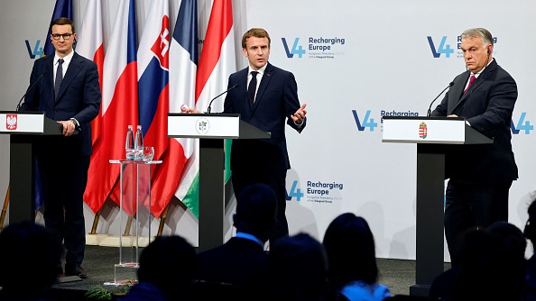 Le président français Emmanuel Macron ( au centre), le premier ministre hongrois Viktor Orban (à droite) et le premier ministre polonais Mateusz Morawiecki (à gauche) s'adressent à la presse après leurs entretiens avec les premiers ministres des quatre pays de Visegrad (V4) au Castle Garden Bazaar à Budapest, le 13 décembre 2021. (Photo : LUDOVIC MARIN/AFP via Getty Images)