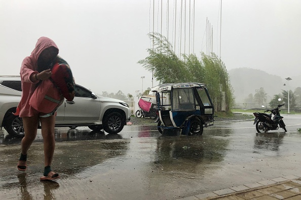 Un touriste local arrive pour se réfugier dans un complexe sportif transformé en centre d'évacuation dans la ville de Dapa, sur l'île de Siargao, le 16 décembre 2021, alors que le typhon Rai frappe l'île. Photo par Roel CATOTO / AFP via Getty Images.