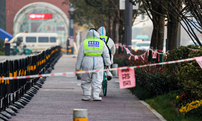 Des gardes de sécurité marchent dans une zone soumise à des restrictions, suite à une récente éclosion de coronavirus dans la ville de Xi'an, dans la province de Shaanxi, Chine, le 22 décembre 2021. (STR/AFP via Getty Images)