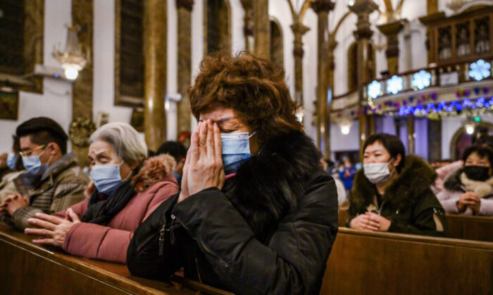 Des chrétiens chinois prient pendant une messe de Noël dans une église catholique à Pékin, en Chine, le 24 décembre 2020. (Kevin Frayer/Getty Images)