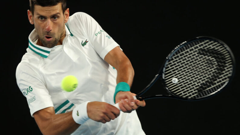 Le Serbe Novak Djokovic frappe un retour contre le Canadien Milos Raonic pendant leur rencontre en simple messieurs lors de la septième journée de l'Open d'Australie de tennis à Melbourne, en Australie, le 14 février 2021. (Brandon Malone/AFP via Getty Images)