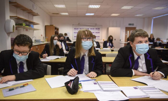 Des élèves de 3e portent des masques faciaux alors qu'ils participent à un cours de sciences à la Park Lane Academy à Halifax, dans le nord-ouest de l'Angleterre, le 4 janvier 2022. (Oli Scarff/AFP via Getty Images)