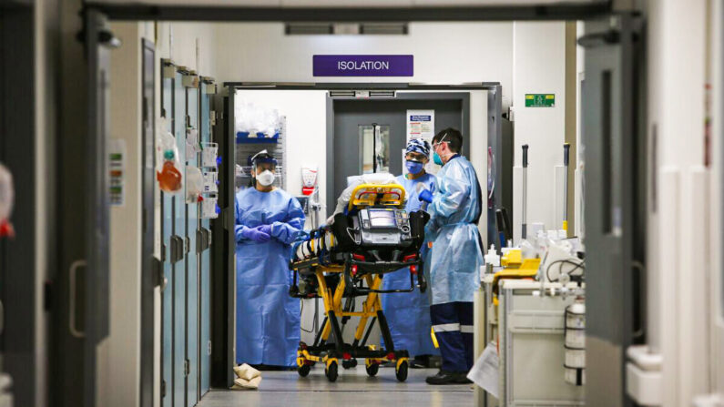 Le Dr Kevin Maruno, spécialiste en médecine d'urgence, et l'équipe médicale emmènent un patient suspecté d'être atteint du Covid-19 dans la salle d'isolement de la zone rouge du service des urgences de l'hôpital St Vincent à Sydney, en Australie, le 4 juin 2020. (Photo : Lisa Maree Williams/Getty Images)