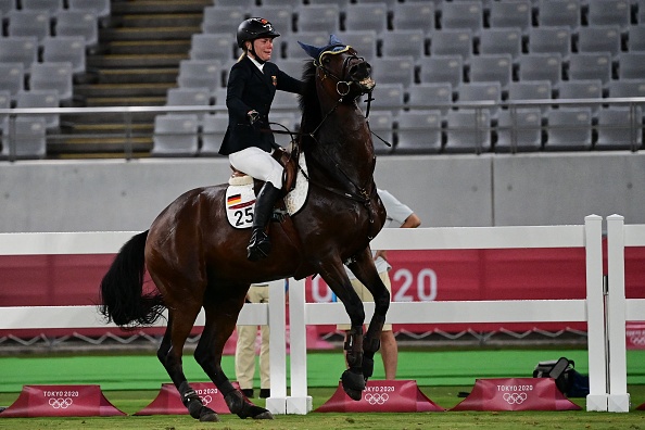 -L'Allemande Annika Schleu se débat en chevauchant Saint- Boy dans le pentathlon moderne de saut d'obstacles individuel féminin lors des Jeux Olympiques de Tokyo 2020 le 6 août 2021. Photo de Pedro PARDO / AF via Getty Images.