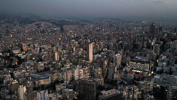 Cette photo prise le 11 octobre 2021 montre une vue aérienne de Beyrouth, la capitale du Liban, au coucher du soleil, avec des bâtiments dans l'obscurité pendant une panne de courant.  (Photo : -/AFP via Getty Images)