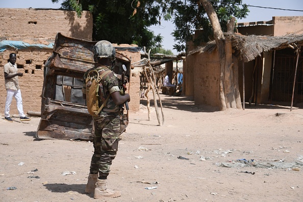 -Un soldat nigérien monte la garde dans une rue près d'un marché à Banibangou, une ville de l'ouest du Niger, où des personnes sont mortes dans une embuscade djihadiste. Photo de BOUREIMA HAMA / AFP via Getty Images.