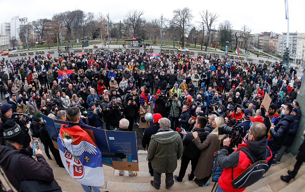 Des personnes agitent des drapeaux nationaux serbes lors d'un rassemblement devant l'Assemblée nationale de Serbie, alors que le numéro un mondial du tennis, Novak Djokovic, lutte contre son expulsion d'Australie après l'annulation de son visa, le 6 janvier 2022 à Belgrade, en Serbie. (Photo : Srdjan Stevanovic/Getty Images)