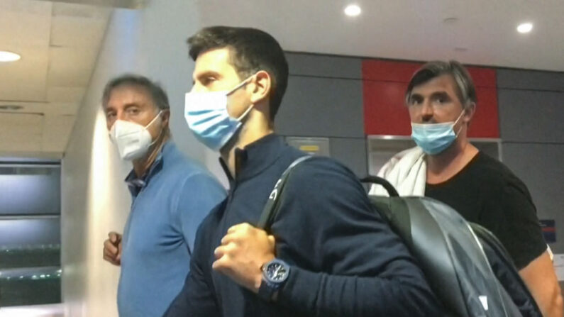 Novak Djokovic (au centre) marche devant son entraîneur Goran Ivanisevic (à droite) après avoir débarqué de son avion à l'aéroport de Dubaï, le 17 janvier 2022 (Photo par STR/AFPTV/AFP via Getty Images)