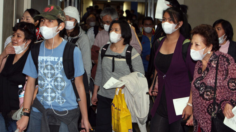 Des passagers sortent d'un avion en provenance du Mexique via Vancouver, Canada, à l'aéroport international de Narita  (Photo par Junko Kimura/Getty Images)