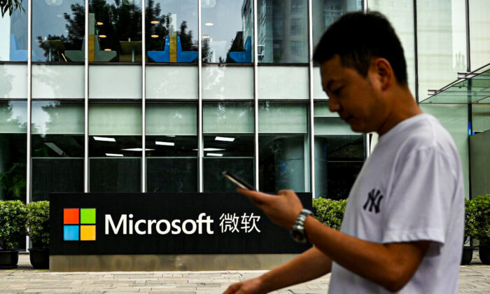 Un homme utilise son téléphone portable devant le siège local de Microsoft à Pékin, le 20 juillet 2021. (Noel Celis/AFP via Getty Images)
