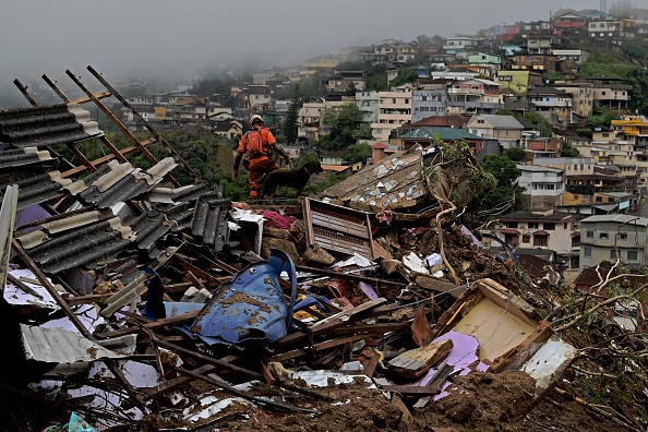 Un membre de l'équipe de secours des pompiers soulève les décombres pour rechercher des survivants après un glissement de terrain à Petrópolis, au Brésil, le 16 février 2022. Photo CARL DE SOUZA/AFP via Getty Images.