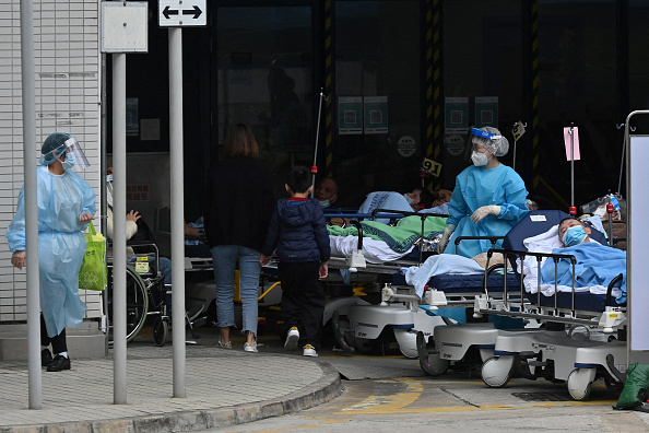 -Des personnes sont allongées dans des lits à l'extérieur du centre médical Caritas à Hong Kong le 18 février 2022. Photo de Peter PARKS / AFP via Getty Images.