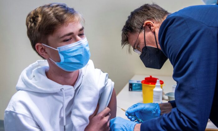 Le ministre allemand de la Santé, Karl Lauterbach, à droite, administre un vaccin Pfizer à un homme au centre de vaccination du Palais des sports et des congrès de Schwerin, en Allemagne, le 17 janvier 2022. (Jens Buettner/Pool via AP)