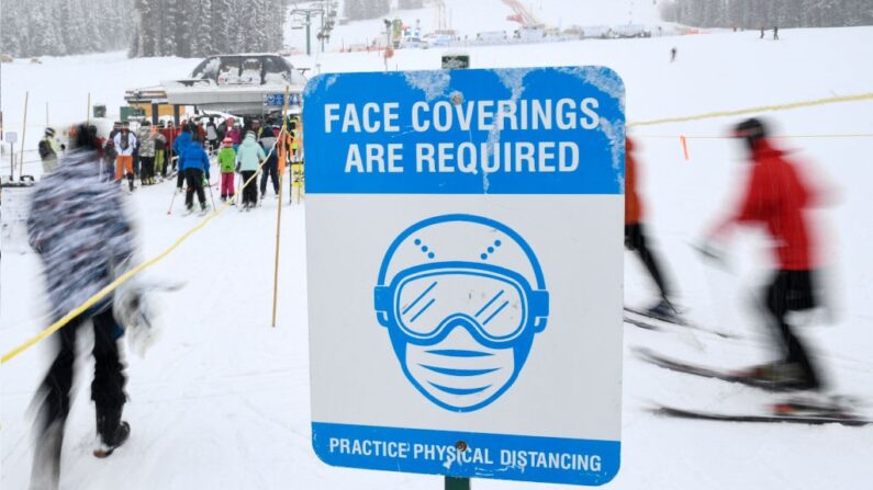 Panneau exigeant des masques faciaux pour pouvoir utiliser une remontée mécanique à la station de ski de Lake Louise, dans l'Alberta, au Canada, le 28 novembre 2021. - Les visiteurs doivent aussi présenter une preuve de vaccination contre le Covid-19, une exemption ou un test négatif pour entrer dans les zones intérieures de la station. (Photo de PATRICK T. FALLON/AFP via Getty Images)