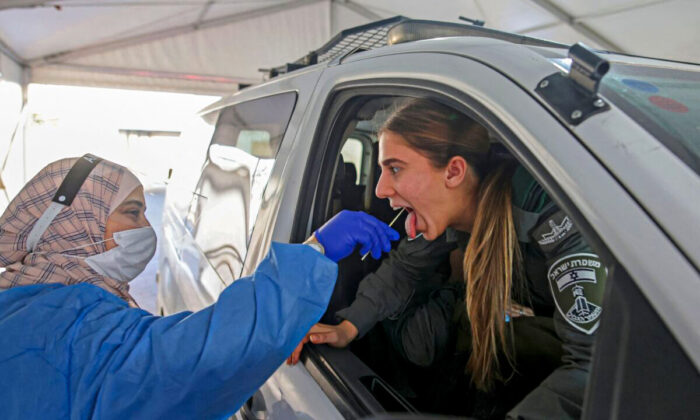 Un médecin prélève un échantillon par écouvillonnage sur un garde-frontière israélien dans un centre de dépistage du Covid-19, sur une photo d'archive. (Ahmad Gharabli/AFP via Getty Images)