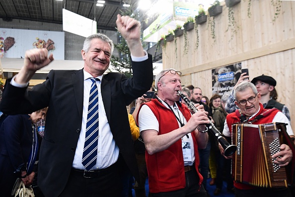 Le candidat à la présidence du parti "Résistons !" Jean Lassalle danse avec des musiciens alors qu'il visite le 58e Salon international de l'agriculture, le 2 mars 2022.  (BERTRAND GUAY/AFP via Getty Images)