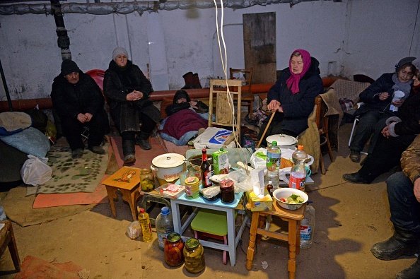 Des personnes âgées s'abritent dans le sous-sol d'un immeuble avec des effets personnels, après que les troupes russes ont bombardé la zone de la deuxième plus grande ville ukrainienne de Kharkiv, le 6 mars 2022. Photo de Sergey BOBOK / AFP via Getty Images.