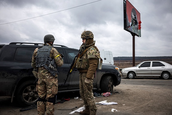 Des militaires ukrainiens montent la garde sur un pont détruit près de la ville d'Irpin, au nord-ouest de Kiev, le 13 mars 2022. (Photo : DIMITAR DILKOFF/AFP via Getty Images)