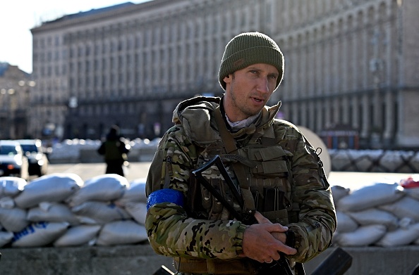 -L'ancien joueur de tennis ukrainien Sergiy Stakhovsky sur la place de l'Indépendance à Kiev, le 15 mars 2022. Il patrouille pour protéger Kiev en treillis militaire et avec un fusil d'assaut Kalachnikov. Photo de Sergei SUPINSKY / AFP via Getty Images.