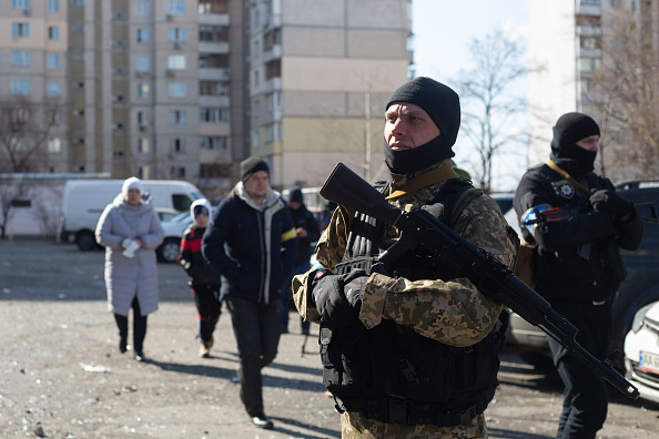 Un militaire ukrainien se tient près d'un immeuble résidentiel touché par des débris de roquettes le 17 mars 2022 à Kiev, en Ukraine. (Photo : Anastasia Vlasova/Getty Images)