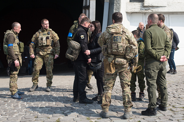 - Des militaires ukrainiens réconfortent la veuve de Vladyslav Buvalkin, 42 ans, décédé au combat et enterré aujourd'hui, le 23 mars 2022 à Kiev, en Ukraine. Photo par Anastasia Vlasova/Getty Images.