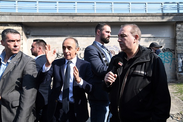 Eric Zemmour, accompagné de l'animateur et journaliste français Jean-Marc Morandini, visite la colline dite du crack près de la porte de la Villette, le 25 mars 2022 à Paris.  (BERTRAND GUAY/AFP via Getty Images)