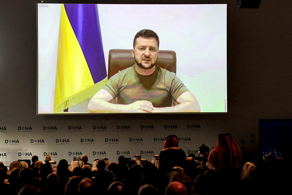 -Le président ukrainien Volodymyr Zelensky s'adresse à distance par liaison vidéo au Forum de Doha dans la capitale du Qatar le 26 mars 2022. Photo de KARIM JAAFAR/AFP via Getty Images.