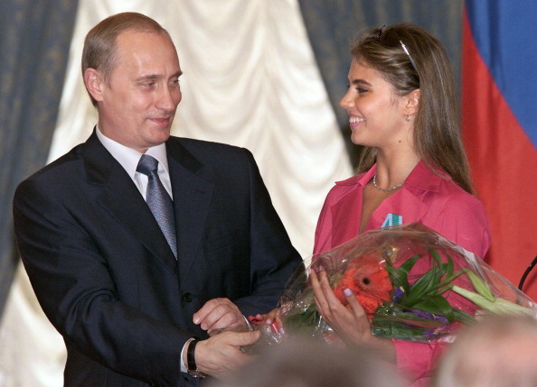 Le président russe Vladimir Poutine et Alina Kabayeva, au Kremlin le 8 juin 2001.   (SERGEI CHIRIKOV/AFP via Getty Images)