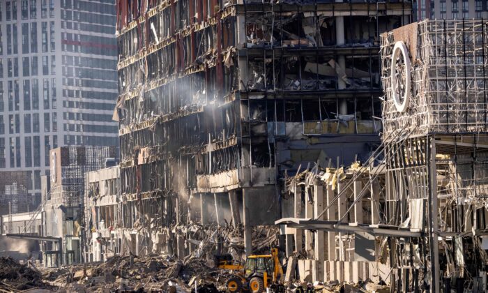 Des pompiers ukrainiens travaillent au milieu des décombres du centre commercial Retroville le lendemain de son bombardement par les forces russes dans un quartier résidentiel de Kiev, capitale de l’Ukraine, le 21 mars 2022. (Fadel Senna/AFP via Getty Images)