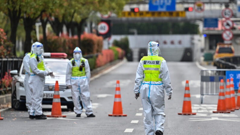 Des policiers portant des équipements de protection contrôlent l'accès à un tunnel en direction du district de Pudong lors du confinement à Shanghai, le 28 mars 2022. (HECTOR RETAMAL/AFP via Getty Images)