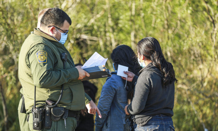 Des gardes-frontières appréhendent des immmigrés clandestins qui viennent de traverser le Rio Grande du Mexique vers les États-Unis, à La Joya, au Texas, le 14 janvier 2022. (Charlotte Cuthbertson/Epoch Times)