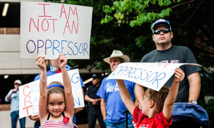 Des enfants brandissent des pancartes lors d'un rassemblement contre l'enseignement de la théorie de la race critique dans les écoles, au centre gouvernemental du comté de Loudoun à Leesburg, en Virginie, le 12 juin 2021. (Andrew Caballero-Reynolds/AFP via Getty Images)