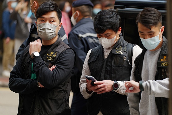 -Des agents de la police de la sécurité nationale de Hong Kong, lors de la perquisition du média local Stand News à Hong Kong le 29 décembre 2021. Photo de Daniel SUEN / AFP via Getty Images.