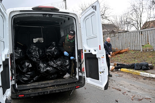 Un travailleur communal charge des sacs mortuaires, dans la ville de Bucha, non loin de la capitale ukrainienne de Kiev, le 3 avril 2022. Photo de Sergei SUPINSKY / AFP via Getty Images.