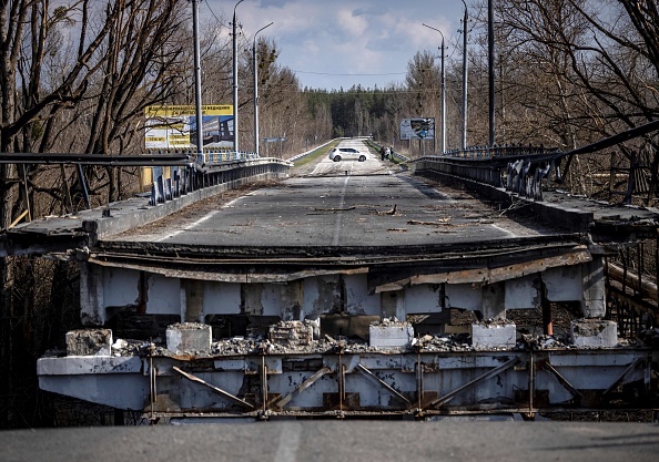 Une voiture effectue un demi-tour devant un pont détruit près du village de Bohorodychne dans la région du Donbass le 5 avril 2022. Photo de FADEL SENNA / AFP via Getty Images.