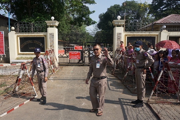 Les responsables de la prison montent la garde alors qu'ils se préparent à la libération des prisonniers à l'extérieur de la prison à Yangon le 17 avril 2022. Photo par STR/AFP via Getty Images.