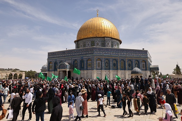 Les Palestiniens agitent des drapeaux islamiques alors qu'ils se rassemblent devant la mosquée du Dôme du Rocher de Jérusalem, le 22 avril 2022. Photo par AHMAD GHARABLI/AFP via Getty Images.