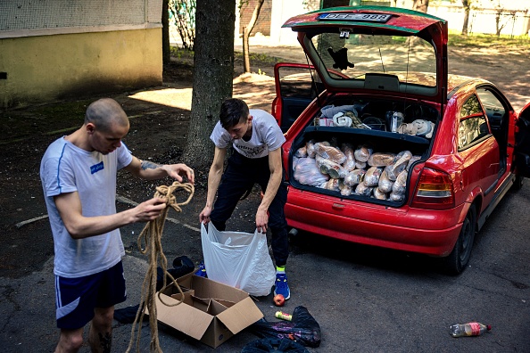 -Alexii et Oleg Vadimovich préparent leur voiture pour acheminer de l'aide humanitaire dans les districts de Kharkiv, dans l'est de l'Ukraine, le 26 avril 2022. Photo de Dimitar DILKOFF/AFP via Getty Images.