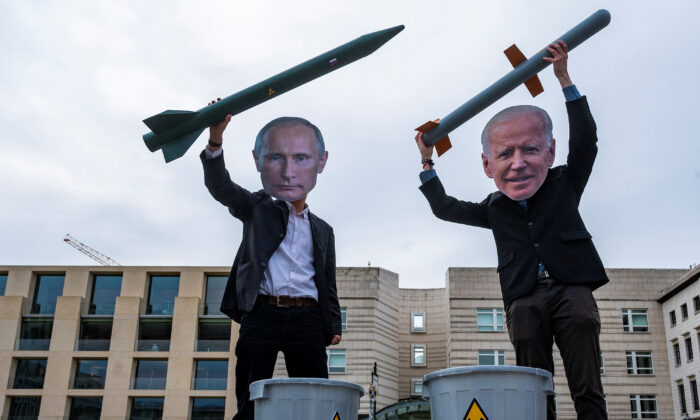 Des militants pacifistes portant des masques du président russe Vladimir Poutine (à g.) et du président américain Joe Biden posent avec des missiles nucléaires factices devant l'ambassade des États-Unis à Berlin, le 29 janvier 2021, lors d'une manifestation réclamant davantage de progrès dans le désarmement nucléaire. (John Macdougall/AFP/Getty Images)