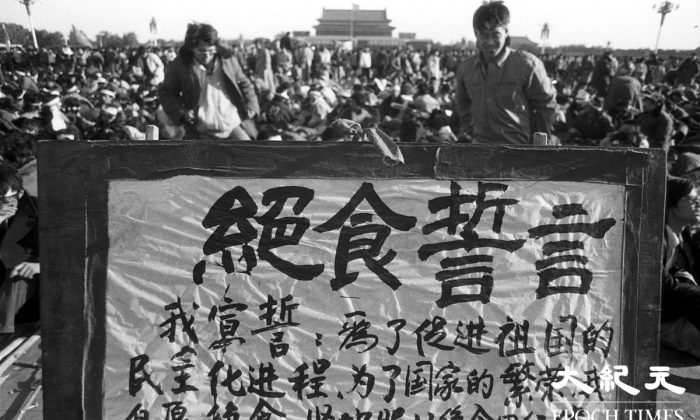 Des étudiants se tiennent derrière une banderole affichant leur détermination de manifester contre l’absence de démocratie en Chine par une grève de la faim sur la place Tiananmen de Pékin, en juin 1989. (Liu Jian/Epoch Times)