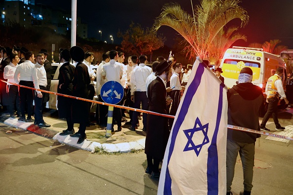 -Des gens se rassemblent sur les lieux d'une attaque dans la ville centrale d'Elad, le 5 mai 2022. Photo de JACK GUEZ/AFP via Getty Images.