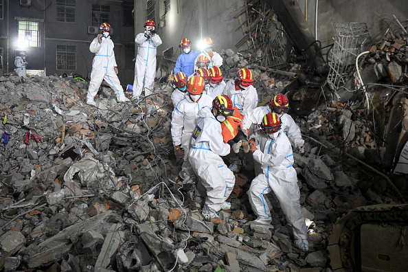 -Des sauveteurs transportent une survivante hors d'un immeuble de six étages effondrés à Changsha, le 5 mai 2022.  Photo par -/CNS/AFP via Getty Images.