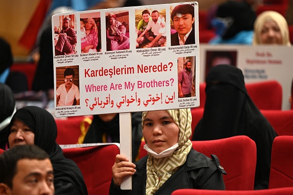 Des membres de la minorité musulmane ouïghoure présentent des photos de leurs proches détenus en Chine lors d'une conférence de presse à Istanbul, le 10 mai 2022.Photo par OZAN KOSE/AFP via Getty Images.