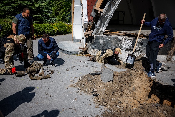 Des enquêteurs et des démineurs recherchent des engins non explosés dans le parc Gorky à Kharkiv, dans l'est de l'Ukraine, le 24 mai 2022. Photo de Dimitar DILKOFF/AFP via Getty Images.