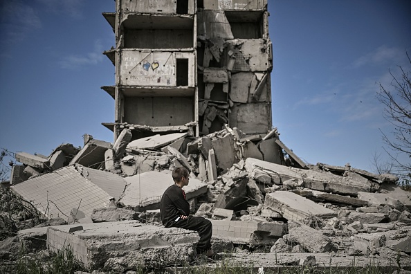  Un jeune garçon est assis devant un bâtiment endommagé après une frappe à Kramatorsk, dans la région de Donbas, dans l'est de l'Ukraine, le 25 mai 2022. (Photo : ARIS MESSINIS/AFP via Getty Images)