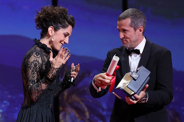 L'actrice iranienne Zar Amir-Ebrahimi aux côtés de l'acteur français Guillaume Canet reçoit le prix de la meilleure actrice pour son rôle dans le film "Holy Spider" au Festival de Cannes, le 28 mai 2022. Photo Valery HACHE / AFP via Getty Images.